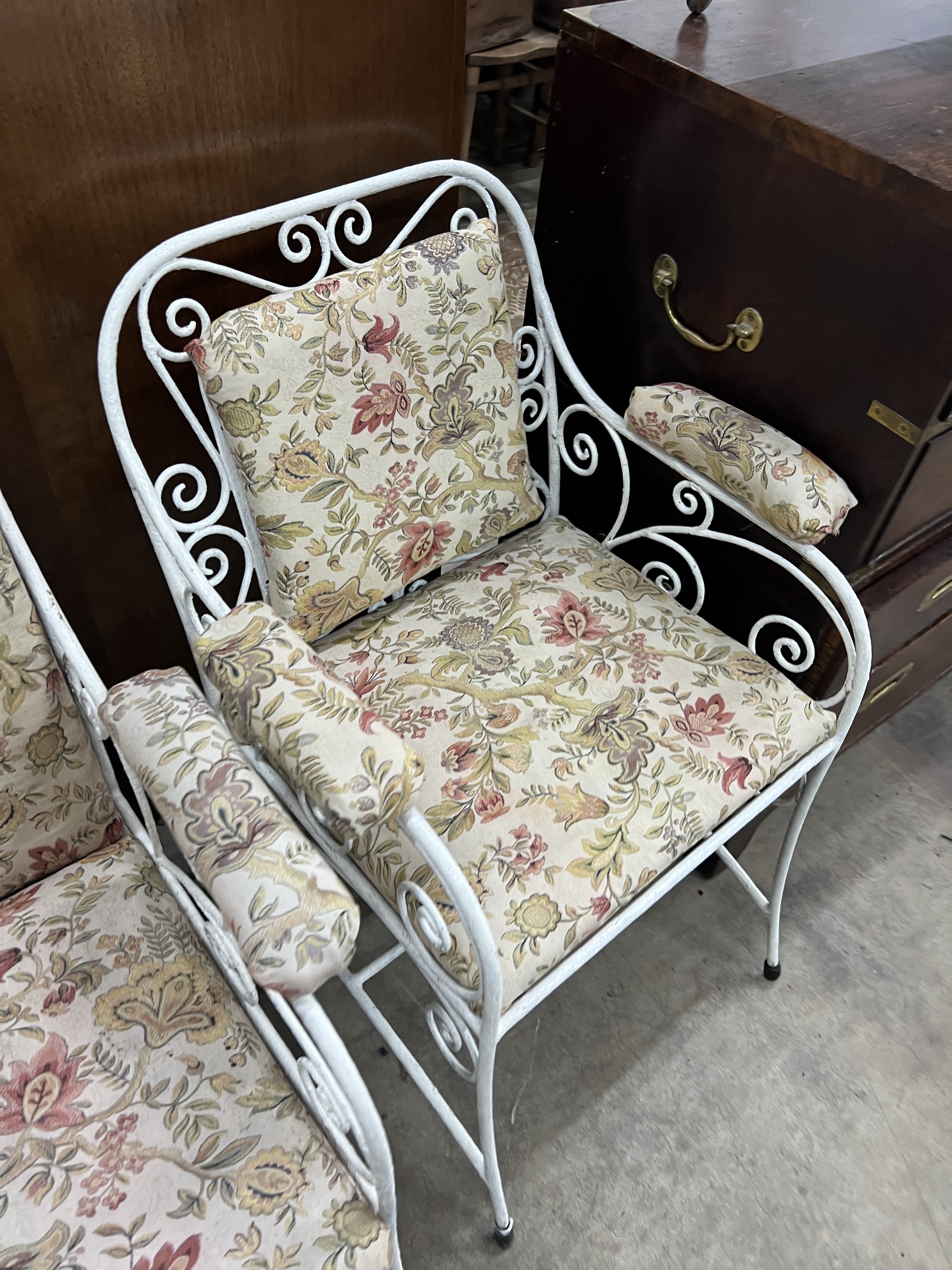 A painted wrought iron upholstered three piece suite, settee length 130cm, width 56cm, height 83cm